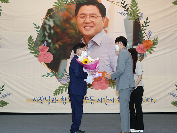 2. 한대희 군포시장이 시 공무원들로부터 아쉬움을 담은 꽃다발을 받고 있다..jpg
