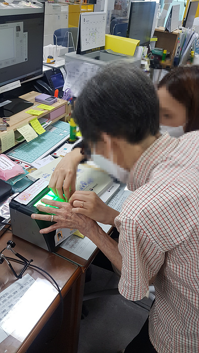 2. [도봉사진] 도봉구 방학2동 주민센터 주민등록 담당 직원이 A씨의 지문을 등록하고 있다.jpg