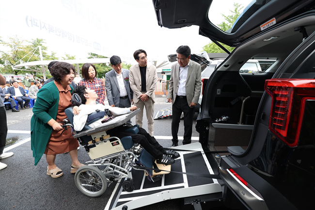 [보도사진1] 지난해 노원구 장애인 전동보장구운전연습장에서 열린 시승식 행사에서 보조기기를 활용해 차량에 탑승하는 시승 장면_250925.jpg